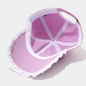 Detailed interior of a pink baseball cap showing lace trim and adjustable strap