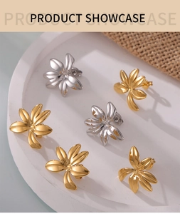 Detail of gold and silver floral stud earrings displayed in a minimalist white tray