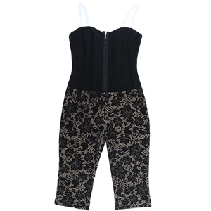 Detail der floralen Spitzentextur und des transparenten Mesh am schwarzen Jumpsuit