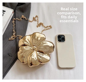 Macro detail of golden flower evening clutch with polished mirror finish and chain