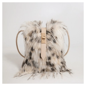 Close-up of fluffy faux fur handbag with black spots and gold metal buckle detail