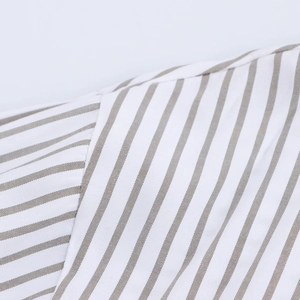 Gros plan détaillé du tissu en coton rayé kaki sur l'épaule et la couture de la manche