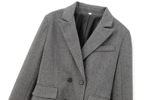 Detailed macro view of grey herringbone wool fabric and double-breasted buttons on the blazer