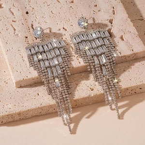 Vue détaillée de boucles d'oreilles argentées avec cristaux et franges scintillantes