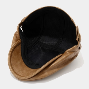 Detail of vintage brown leather flat cap showing breathable black mesh lining and stitching