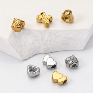 Detail of owl, heart, and bicycle charms in gold and silver finish for DIY jewelry