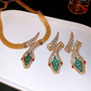 Vintage gold snake jewelry set with necklace and earrings featuring green crystal eyes