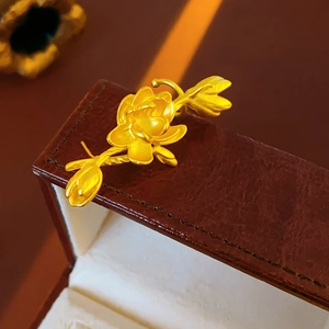 Close-up of a golden metal lotus flower brooch on a premium brown leather jewelry box