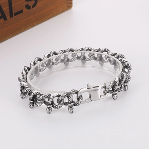 Detailed close-up of retro silver snake chain bracelet with a vintage snake head charm