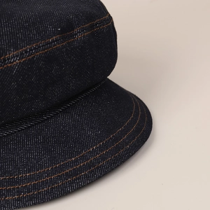 Dark blue denim newsboy hat for women with orange contrast stitching and soft brim