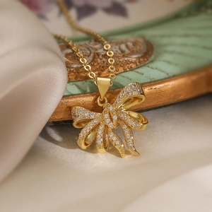Exquisite gold plated bow pendant necklace with sparkling zircon crystals on silk