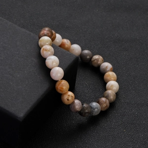 Colorful natural stone beaded bracelet displayed on a matte black jewelry box