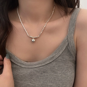 Vintage pearl and silver heart necklace featuring asymmetrical bead and box chain design