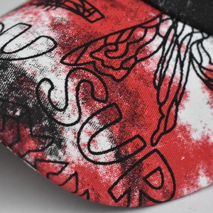 Detail of tie-dye baseball cap brim with honeycomb pattern and letter printing