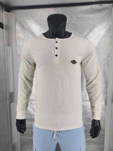 Detail of waffle knit fabric and three-button henley collar on men's long sleeve top