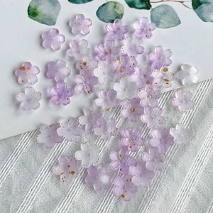 Macro view of purple and white resin flower beads with gold spots for DIY jewelry