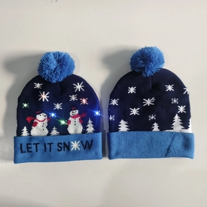 Detail of LED knit Christmas hat with snowflakes and Let It Snow slogan in navy blue