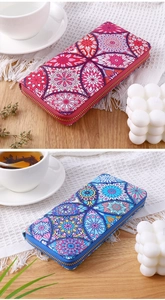 Ethnic style long wallets with mandala floral patterns and gold zippers on a wooden table