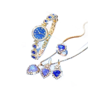 Luxury gold jewelry set with SOKI watch and heart-shaped blue and purple gems