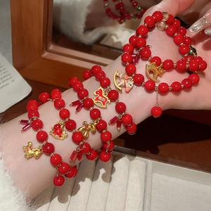 Detail of red beaded bracelets with golden horse charms and traditional Chinese motifs