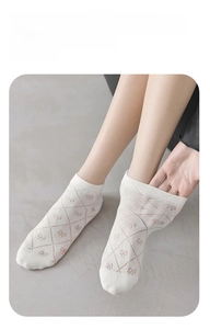Detail of white cotton ankle socks featuring purple lattice patterns and breathable mesh