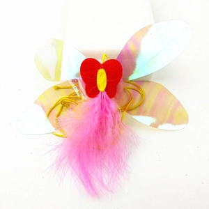 Detail of pink feather cat toy wings with holographic film and butterfly felt on white backdrop