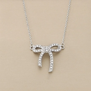 Macro shot of silver bow pendant with shimmering rhinestones on a delicate steel chain
