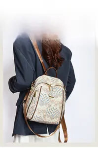 Detail of Chinese wave pattern on backpack with brown leather strap and gold hardware