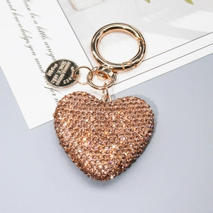Dettaglio portachiavi a cuore in oro rosa con strass scintillanti e finitura lucida