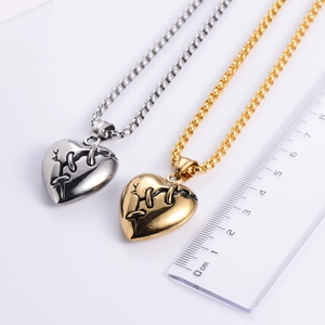 Vintage heart pendant necklaces in gold and silver steel with ruler for size reference