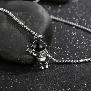 Vue macro d'un pendentif astronaute argenté avec étoile sur un fond de style spatial