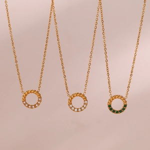 Detail of twisted gold necklaces with pearl, green gemstone, and zircon circle pendants