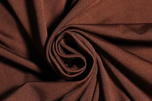 Detailed texture of dark brown knit fabric showing soft pleats and premium material