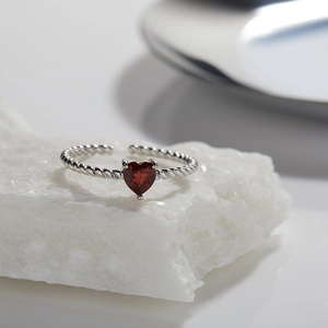 Detail view of heart-shaped red garnet on S925 sterling silver twisted band ring