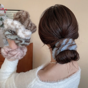 Dettaglio di elastici per capelli in peluche a righe in eleganti colori autunnali