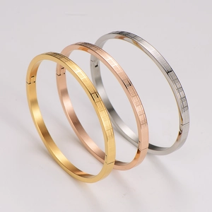 Detail of three-color minimalist metal bracelets in gold, silver, and rose gold finish