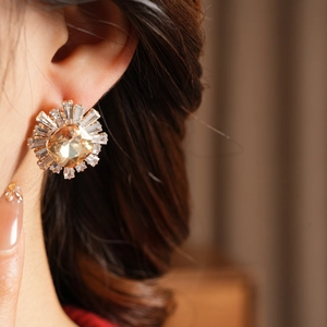 Detail view of sunflower-shaped earring with champagne gemstone and zircon stones