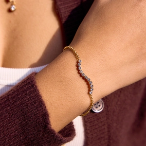 Detail of 18K gold stainless steel bracelet with S-curve zircon on female wrist