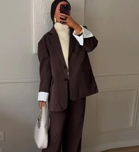 Detail of oversized brown striped blazer featuring wide white turn-back cuffs and lapels
