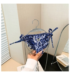 Close-up of blue leopard bikini panty with silver butterfly pendant and side ties