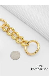Size comparison of a gold chunky metal chain strap with a large round spring buckle clasp
