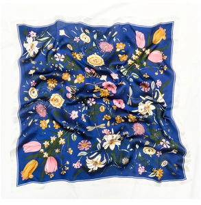 Detail of silk-like square scarf featuring colorful floral patterns on navy blue background