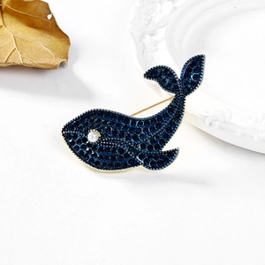 Broche baleine bleue sertie de strass foncés et perle blanche sur monture dorée