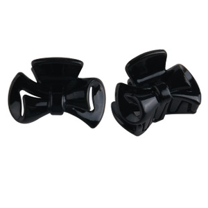 Close-up of two black butterfly hair clips made of polished plastic with a hollow design