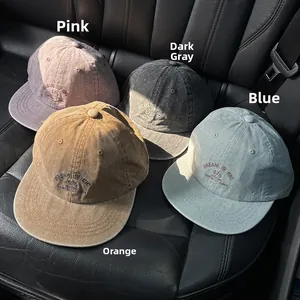 Detail of four retro washed cotton baseball caps with vintage embroidery on leather seat
