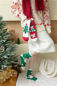 Détail de chaussettes de Noël épaisses en polaire corail avec motifs de cerf et Père Noël