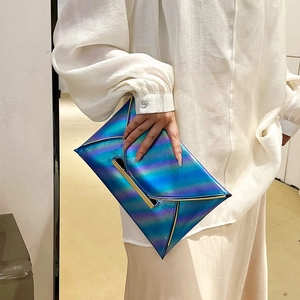 Macro detail of fashionable iridescent envelope clutch with metallic blue-purple gradient finish