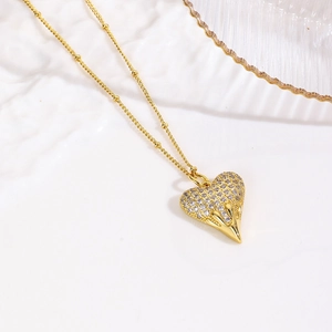 Exaggerated 18k gold plated heart pendant necklace with zircon stones on a white tray