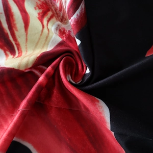 Close-up of floral print fabric showing smooth polyester texture and elegant red white patterns