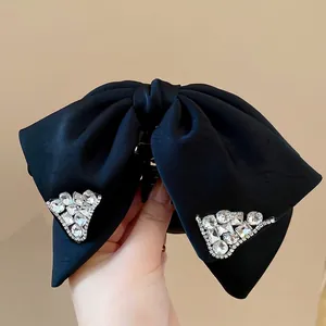 Elegant black satin bow hair claw clip featuring sparkling rhinestone embellishments